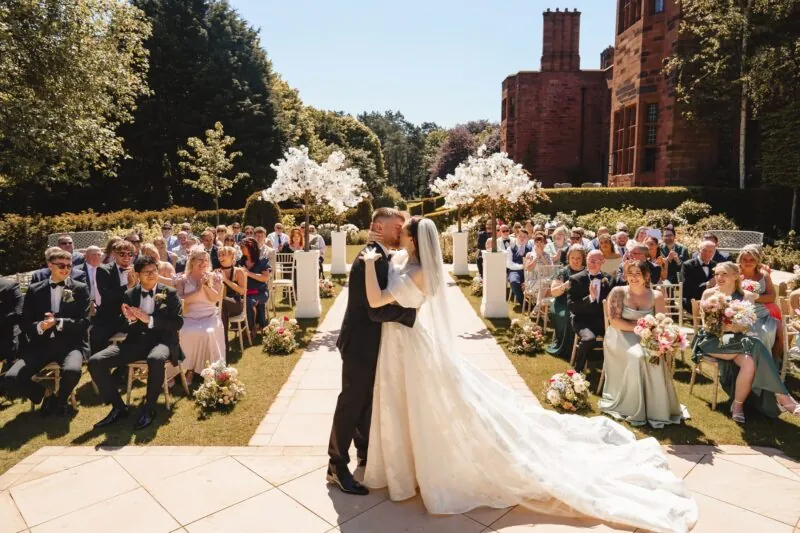 Bride and groom embracing during their wedding in the beautiful gardens of Abbey House Hotel